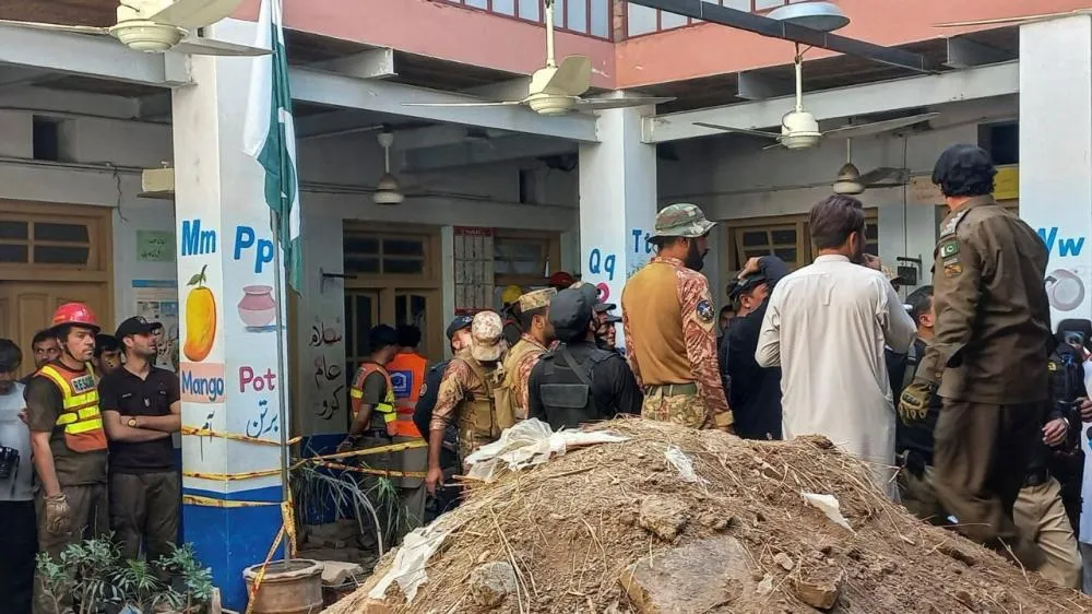 Oficiais do Exército e socorristas em escola cujo teto desabou em Peshawar, no Paquistão | Reuters