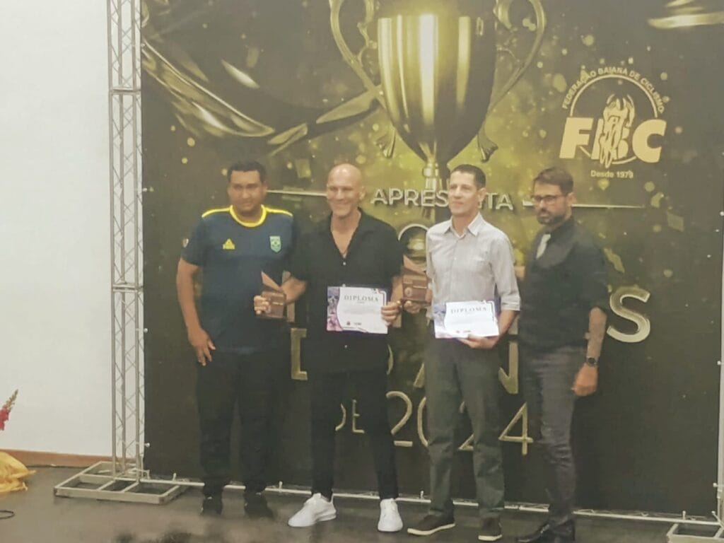 A Federação Baiana de Ciclismo realizou uma cerimônia no auditório da Secretaria de Educação da Bahia no último sábado (22), com o objetivo de homenagear os atletas destacados do ciclismo baiano em 2024. Esta tradição visa reconhecer as personalidades marcantes da modalidade esportiva no estado. Durante a cerimônia, os atletas receberam diplomas e troféus, além de terem suas conquistas apresentadas. Luiz Rogério, piloto de Pojuca, foi um dos homenageados. Ele conquistou o bicampeonato baiano e se classificou em 26º lugar no Brasil na categoria Cruiser Master 50 a 54 anos. Além disso, foi credenciado como participante de corridas nacionais e internacionais. "É um grande orgulho e um sentimento de responsabilidade representar a cidade de Pojuca em todas as competições em que participo. Estou muito feliz em ter conquistado o bicampeonato na minha categoria na temporada 2023/24. Me comprometo a continuar me esforçando intensamente para me destacar ainda mais nessa modalidade esportiva que amo." A homenagem é um reconhecimento ao esforço e dedicação dos atletas, que representam a cidade e o estado em competições nacionais e internacionais. A Federação Baiana de Ciclismo busca promover e valorizar o ciclismo no estado, incentivando a prática esportiva e a competição.